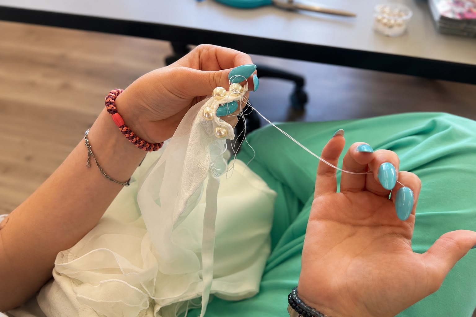 Teilnehmerin im Nähkurs in Gießen näht einen Perlenknopf von Hand an